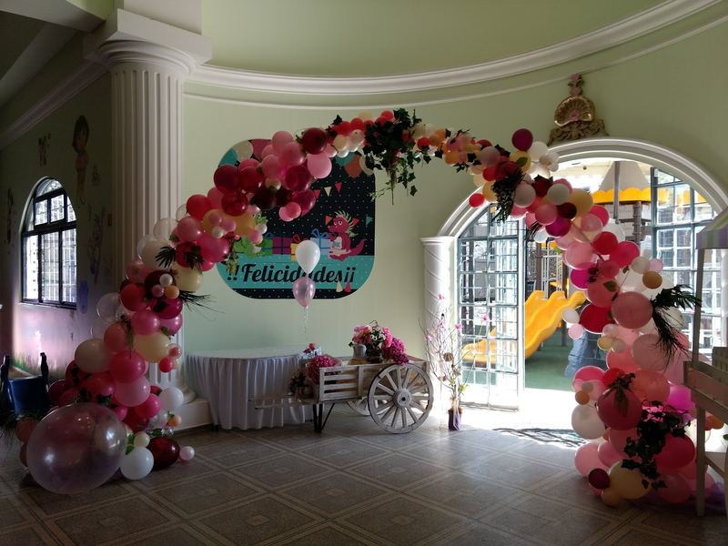 Salón decorado con arco de globos
